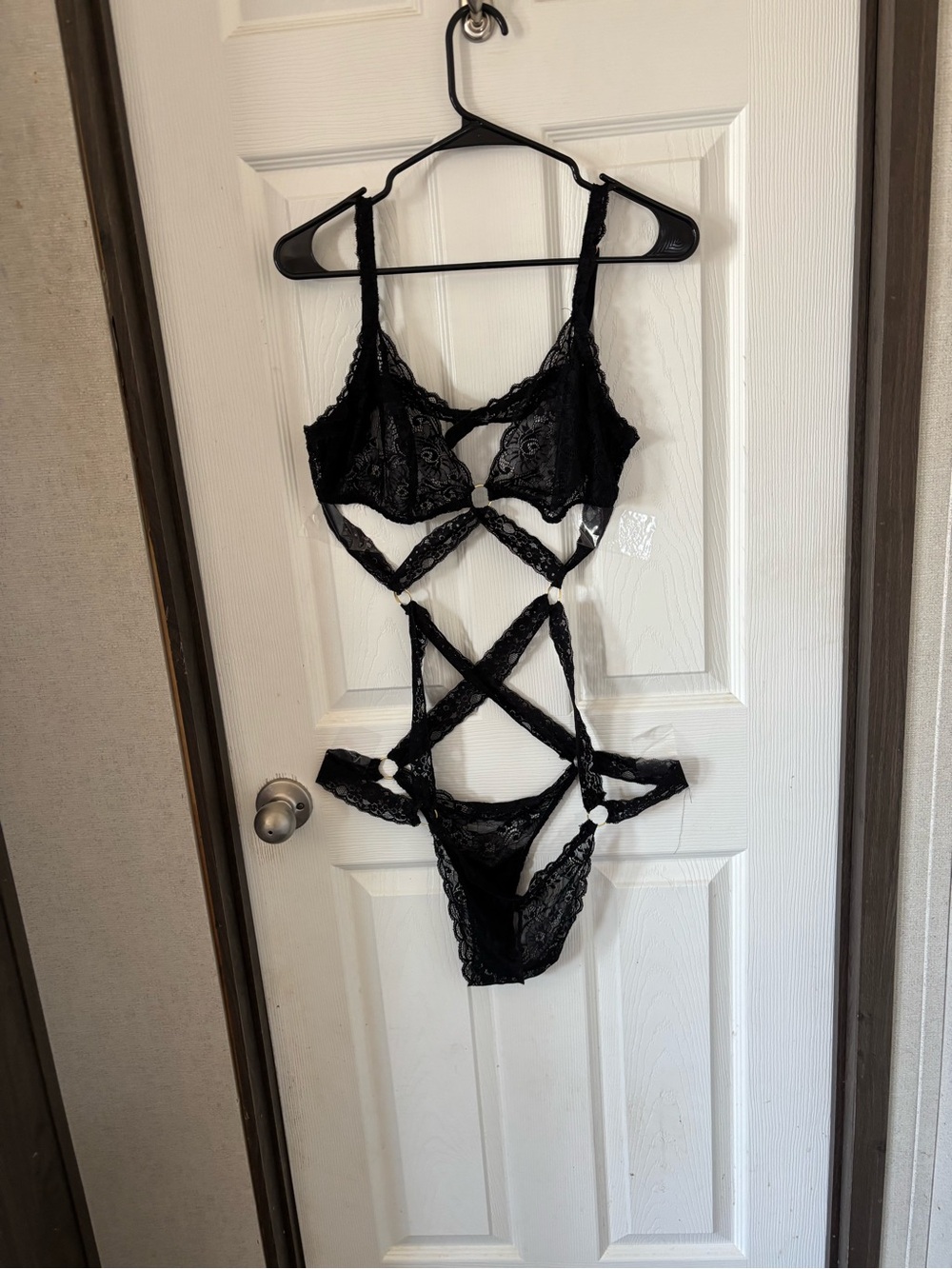 Black lace lingerie set with criss-cross straps and floral embroidery